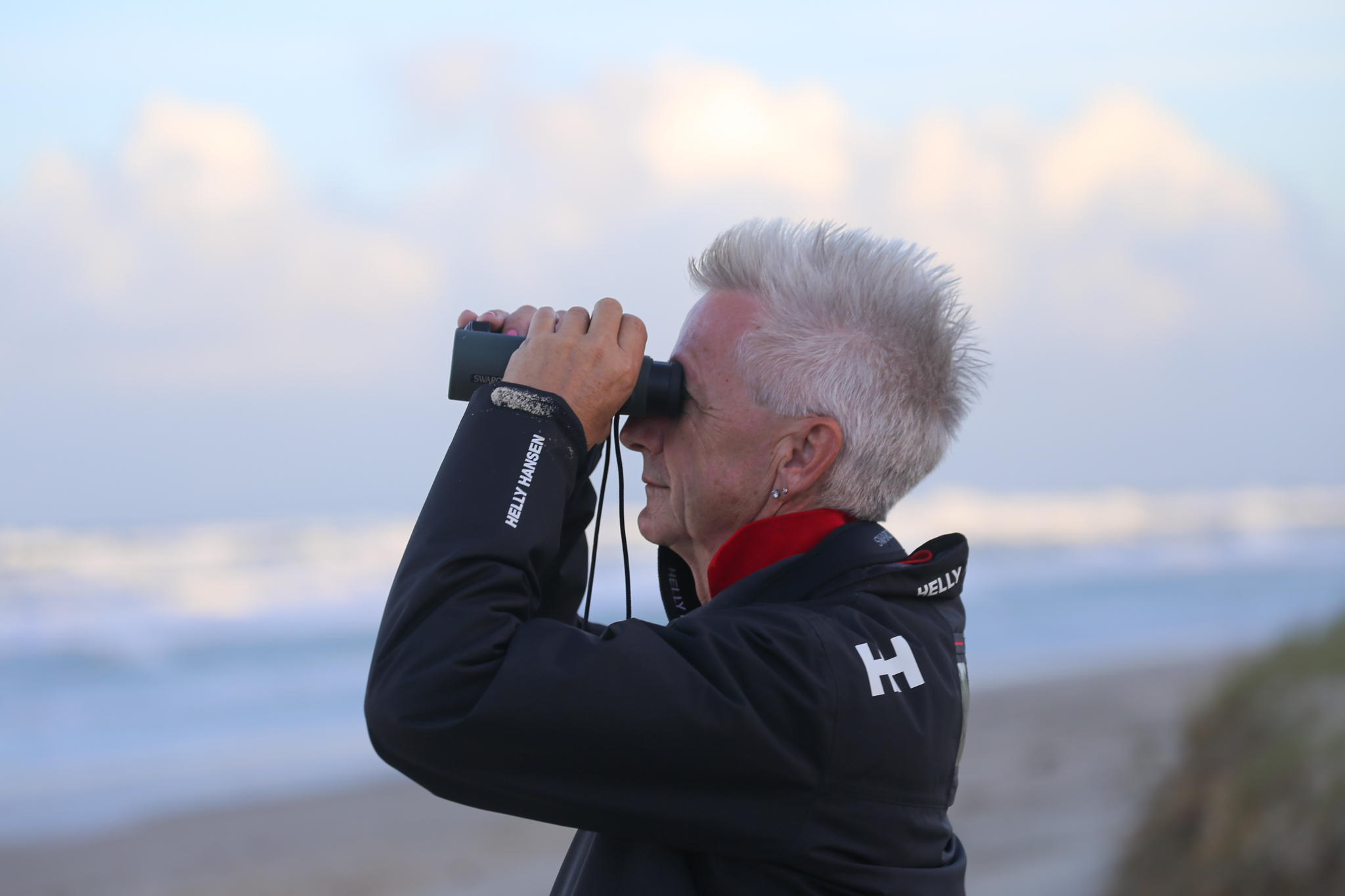 Professor Schlacher looking through binoculars on K'gari