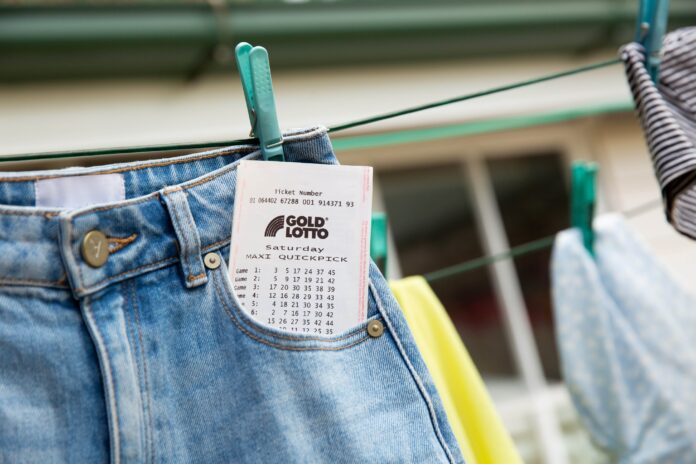 A lotto ticket sticking out of jeans hung on a clothesline.