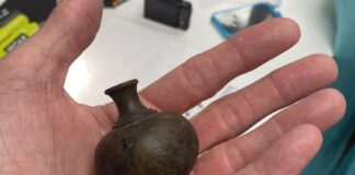 A plum bob being held shown to the camera.