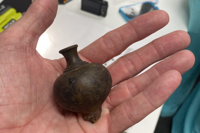 A plum bob being held shown to the camera.
