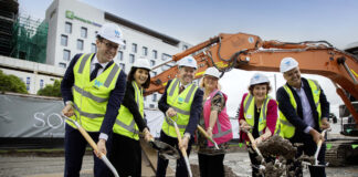 Dignitaries and stakeholders pose with shovels at the site of SOL by Walker.