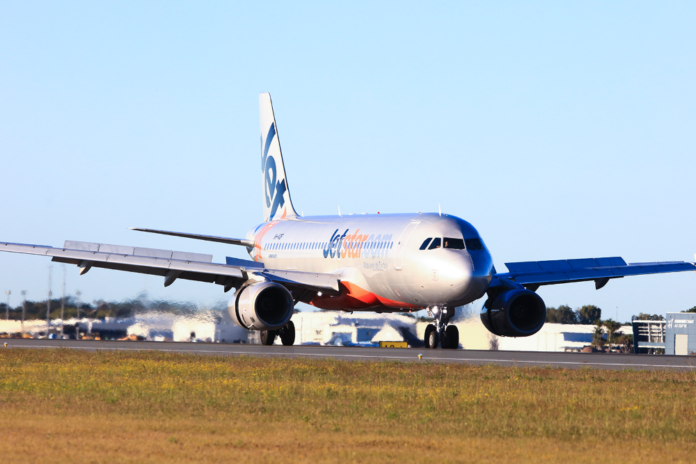 A Jetstar plane landing at Sunshine Coast Airport.