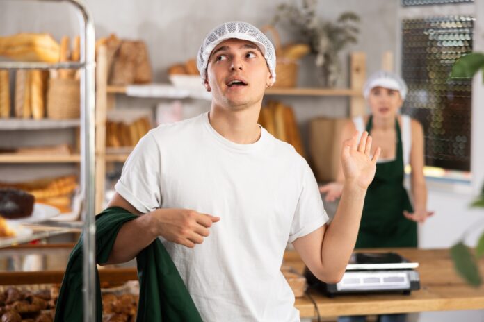 A young baker waves off a work colleague. Picture from Shutterstock.
