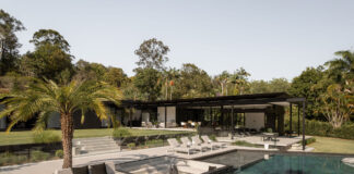 Exterior of a lavish house looking over a pool.