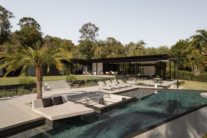 Exterior of a lavish house looking over a pool.