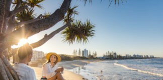 A couple relax in the park overlooking Alexandra Headland beach. Picture: Visit Sunshine Coast.
