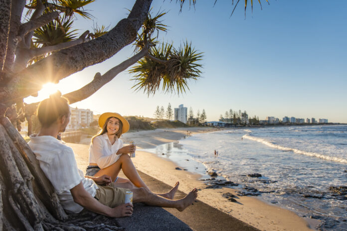 A couple relax in the park overlooking Alexandra Headland beach. Picture: Visit Sunshine Coast.