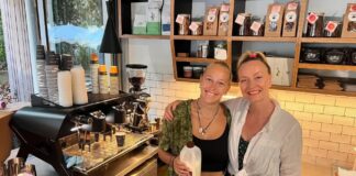 Two women behind the counter of a cafe.