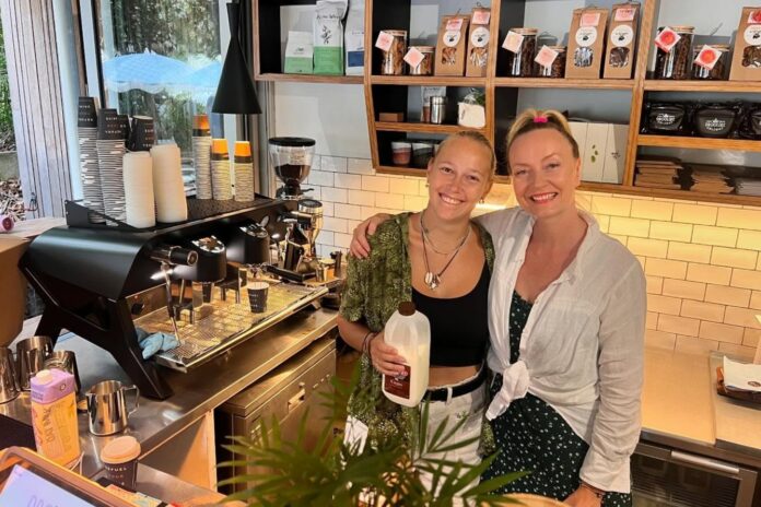 Two women behind the counter of a cafe.