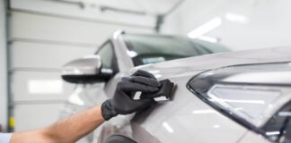 A man applying protective coating to a car.