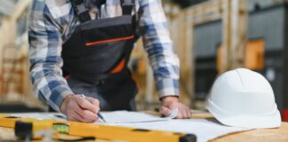 A man working on the frame of a wooden house.