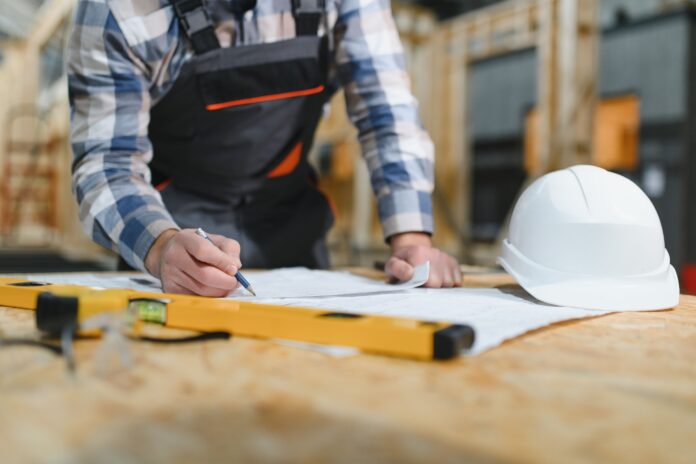 A man working on the frame of a wooden house.