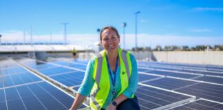 Assistant project manager Nicole Martin with new solar panels on the roof of Sunshine Coast Airport.