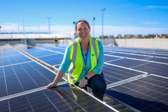 Assistant project manager Nicole Martin with new solar panels on the roof of Sunshine Coast Airport.