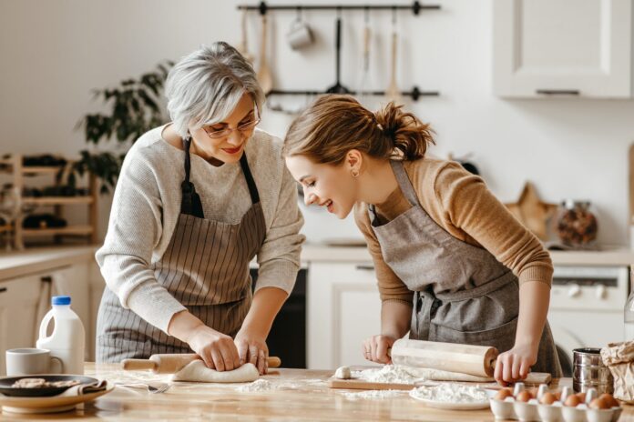 A grandmother and granddaughter knead dough in a kitchen. Picture: Shutterstock.