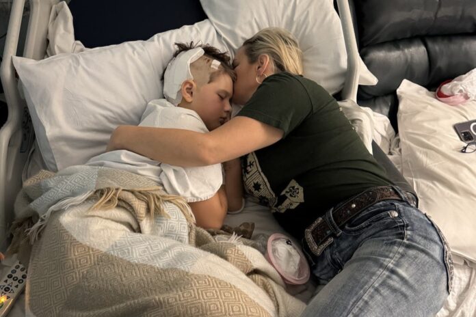Gaving is embraced by his mother Angela Boldt in a hospital bed after an e-scooter crash. Picture by AAP.