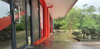 Water gushes out of the doorways of the Jetts gym at Nambour in early March. Picture: Steele Taylor.