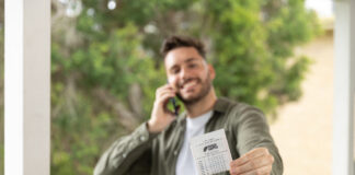 A man shows his Saturday Gold Lotto ticket while he talks on the phone.
