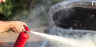A man spraying a fire extinguisher at a car