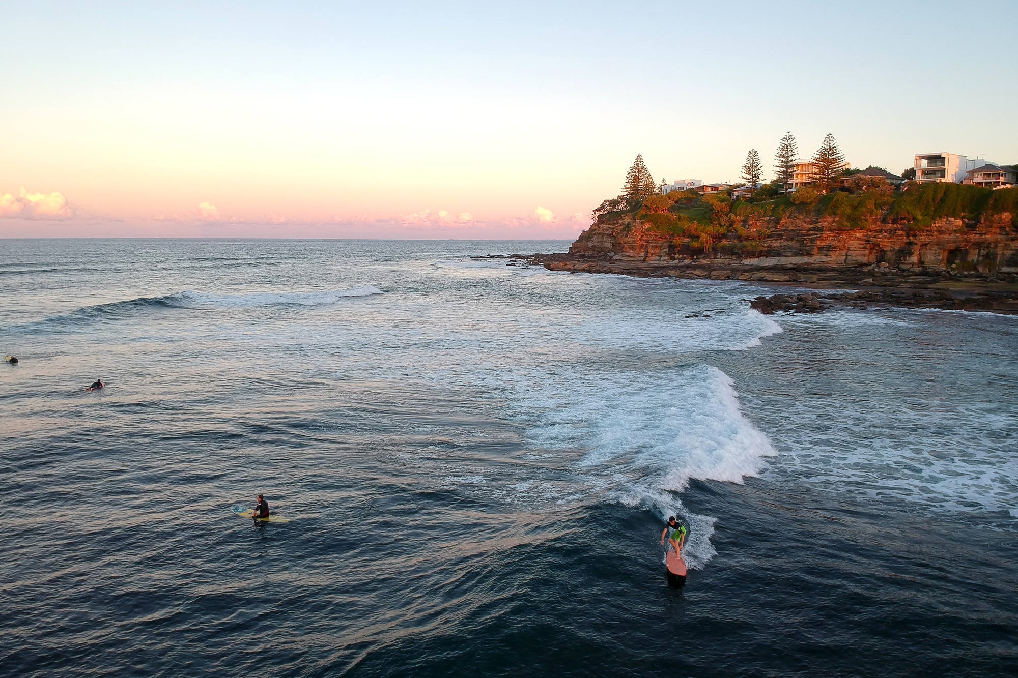 Surfers off Moffat Beach, with Moffat Beach headline in the distance. Picture: Shutterstock.