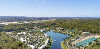 An impression showing a resort with water park, around a lake.