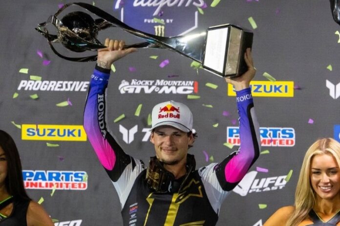 Jettg Lawrence hoists the trophy after winning the SMX World Championship.