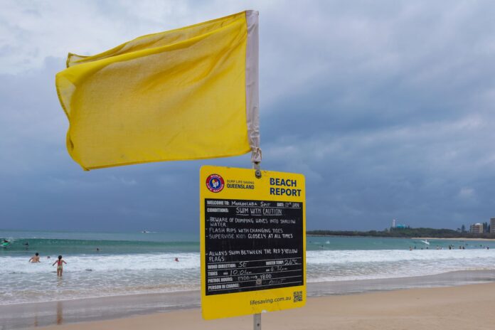 A yellow flag and a sign with surf condition information at Mooloolaba. Picture: Shutterstock.
