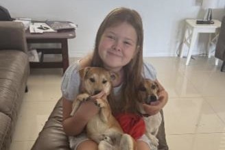 The 11-year-old girl, pictured with two puppies.