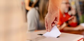A vote being cast in a ballot box.