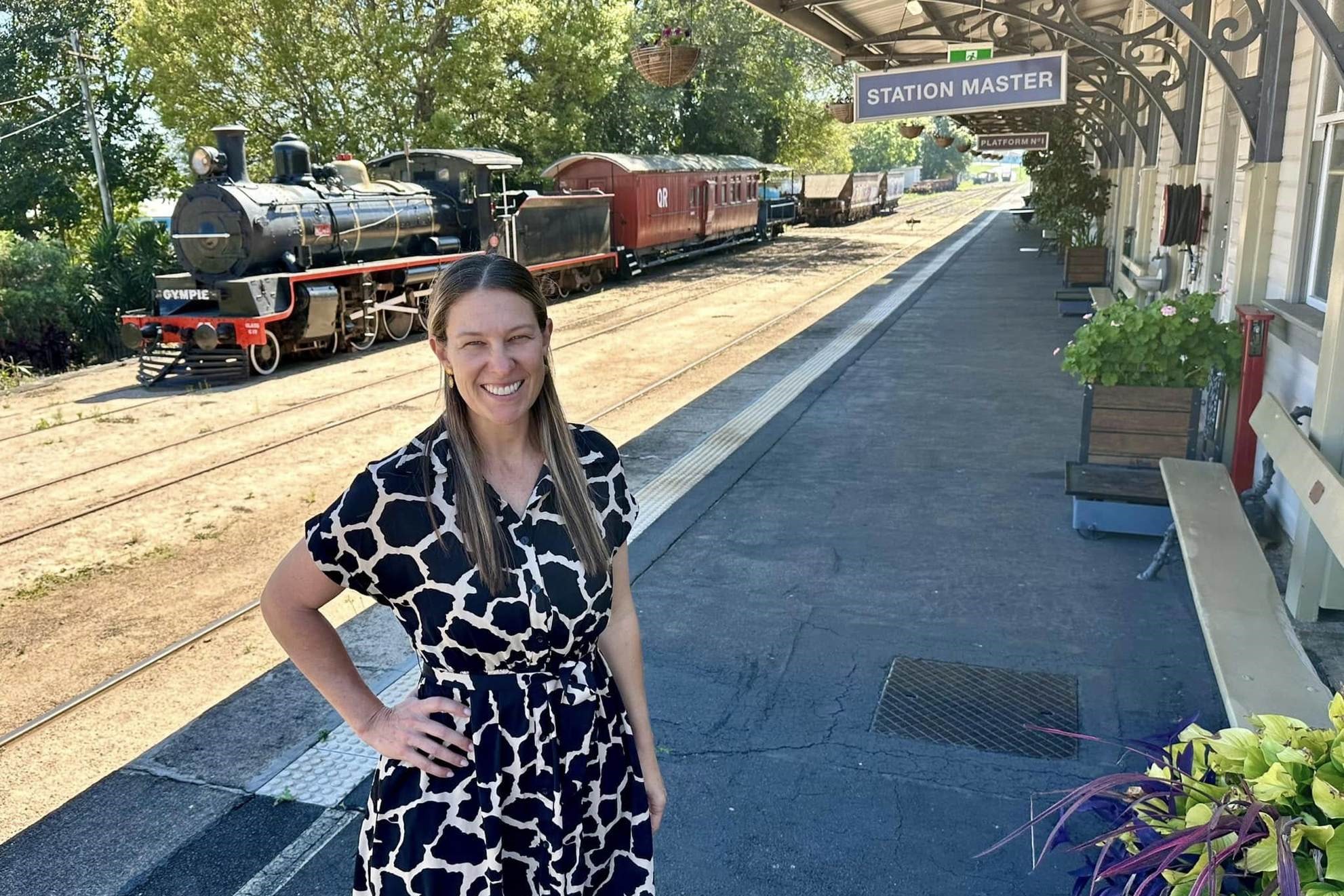 Mary Valley Rattler general manager stands beside the railway track with a train in the background.