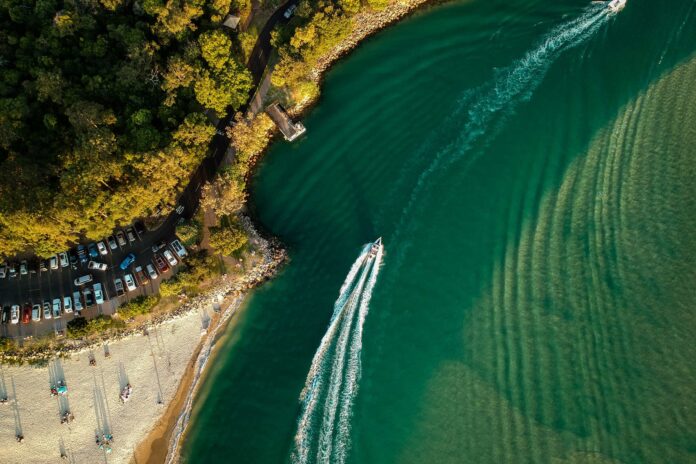 An aerial photo of a boat travelling down the Noosa River.