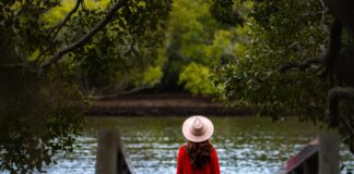 A woman stands on the banks of the Maroochy River.