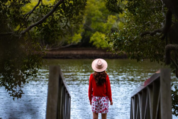 A woman stands on the banks of the Maroochy River.