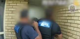 Police at the doorway to a home.