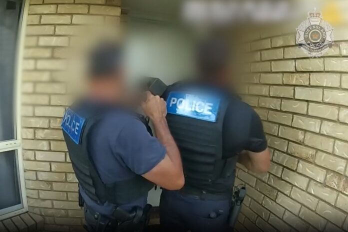 Police at the doorway to a home.