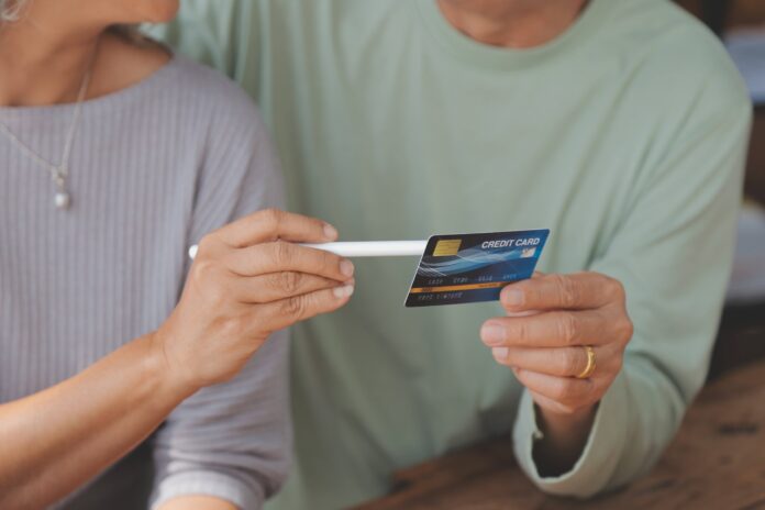 Man and woman holding a credit card. Shutterstock.