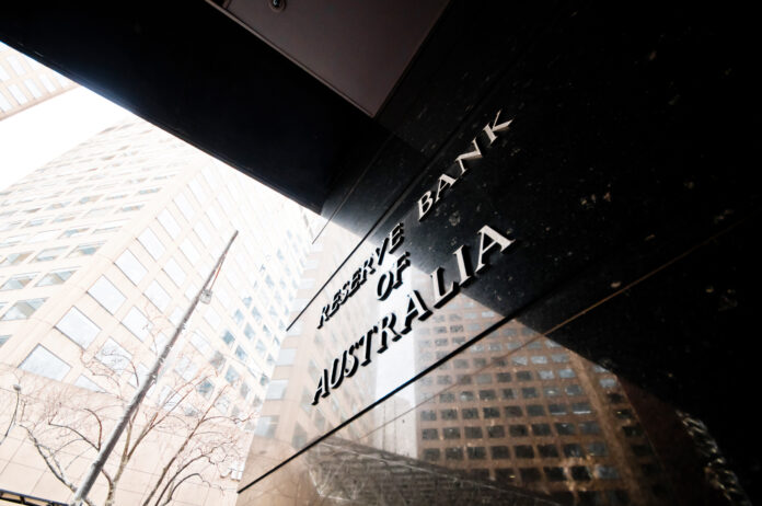 Reserve Bank of Australia name on black granite wall in Melbourne Australia with a reflection of high-rise buildings. The RBA building is located at 60 Collins St, Melbourne VIC 3000 Australia.