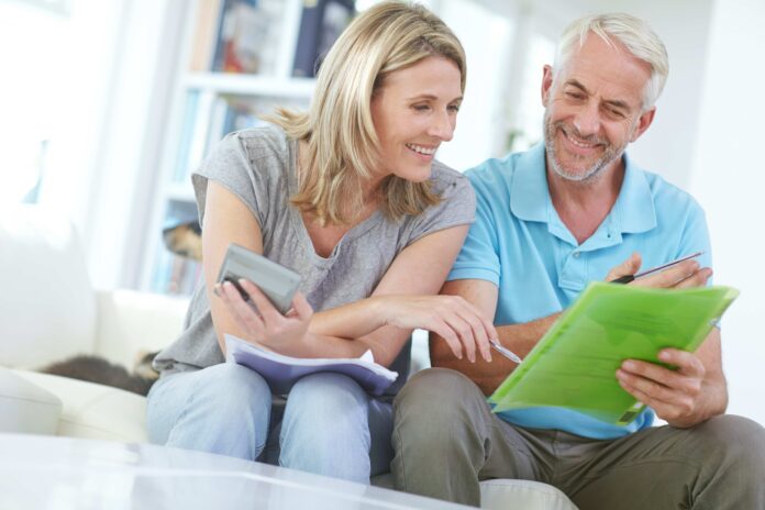 Photo from shutterstock of middle aged couple reviewing their finances