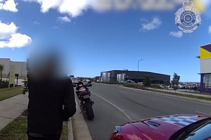 A man beside a police car and motorbike.