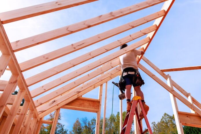A builder working on the frame of a house.