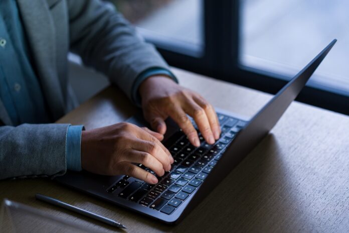 An unidentified man working on a laptop.