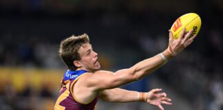 Brisbane Lions player Ty Gallop reaches for the ball.