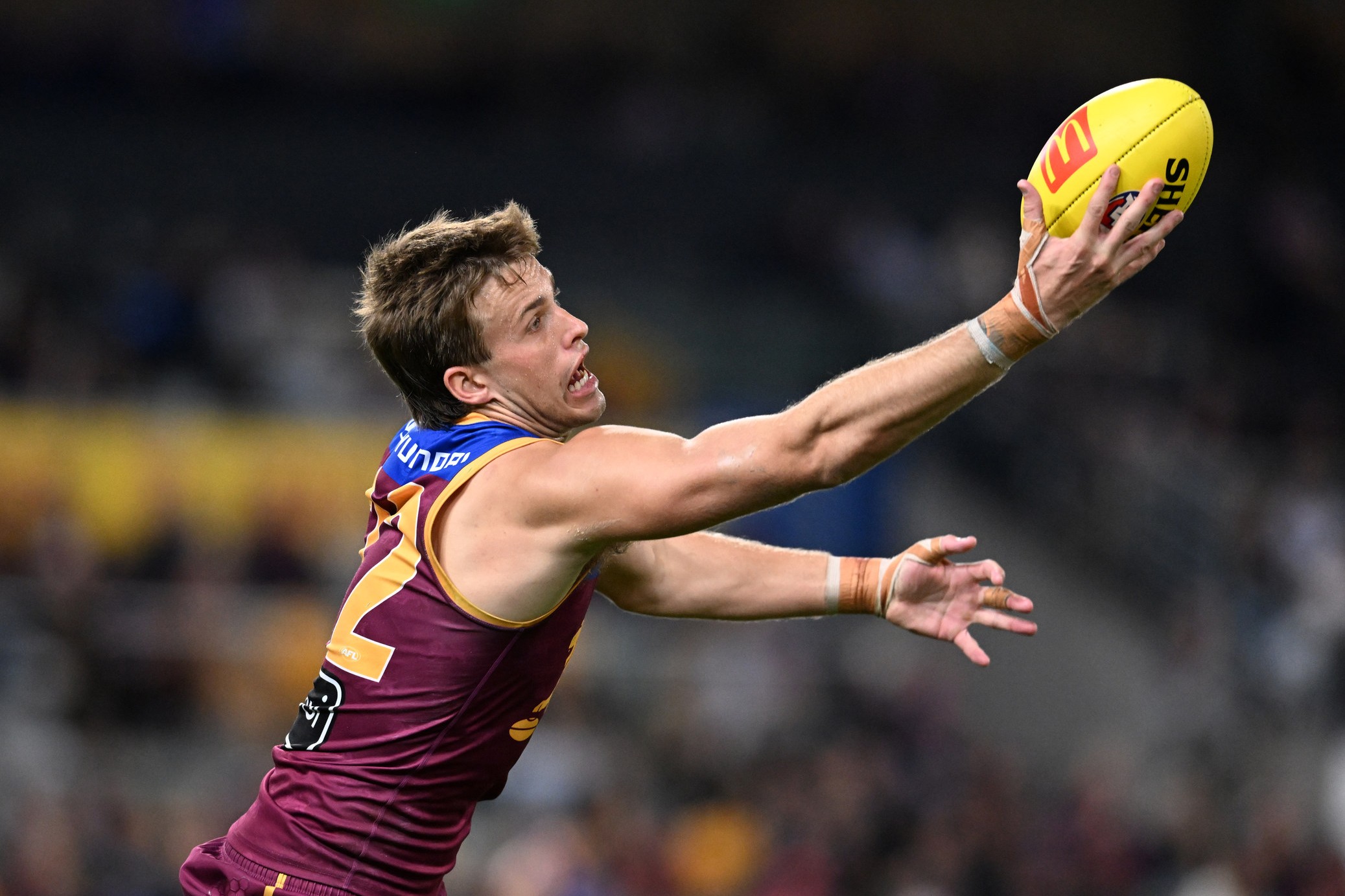 Brisbane Lions player Ty Gallop reaches for the ball.