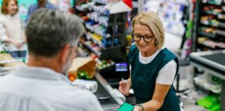 middle aged man paying for groceries shutterstock