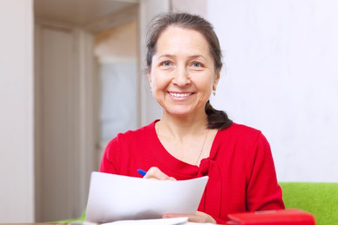 middle aged woman filling out form shutterstock