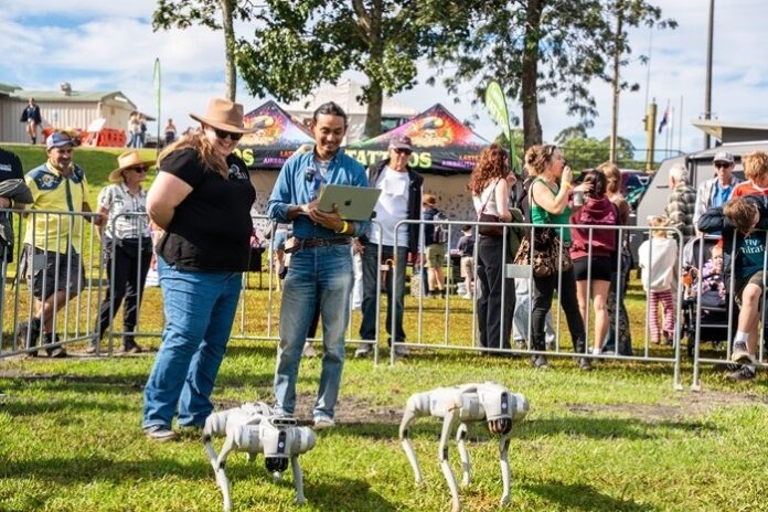 Dr Erica Mealy with UniSC ICT student Abdullah Al Muhsin demonstrating the robodog project at the Maleny Show.