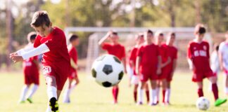 A boy kicks a soccer ball.