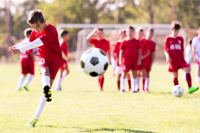 A boy kicks a soccer ball.
