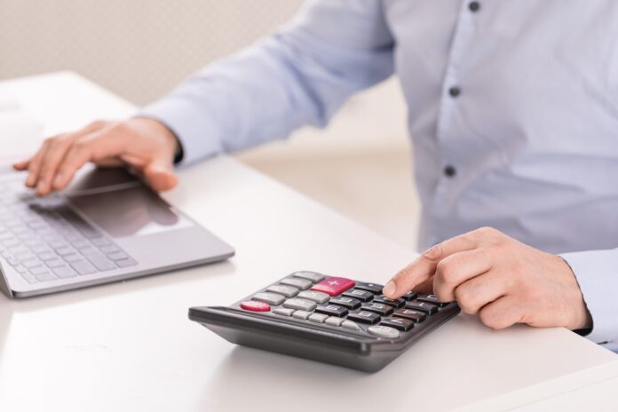 man with calculator shutterstock