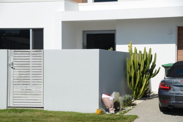 Floral tributes laid at a home in July, 2025.